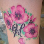Modèle de tatouage fleurs et initiale sur la cheville