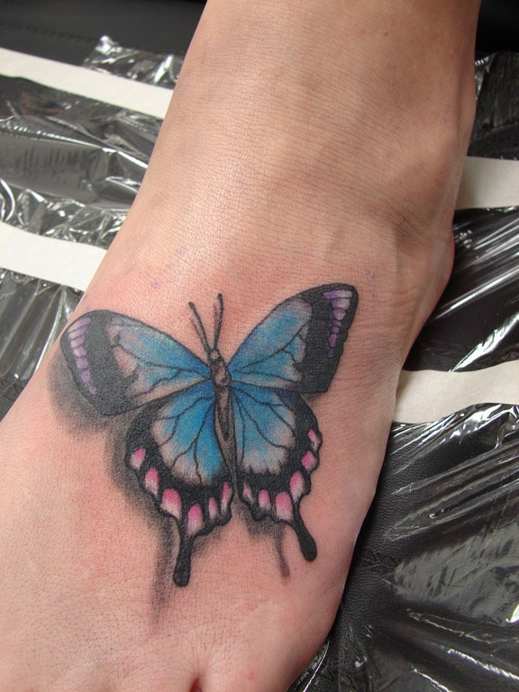 Modèle de tatouage de papillon bleu sur le pied