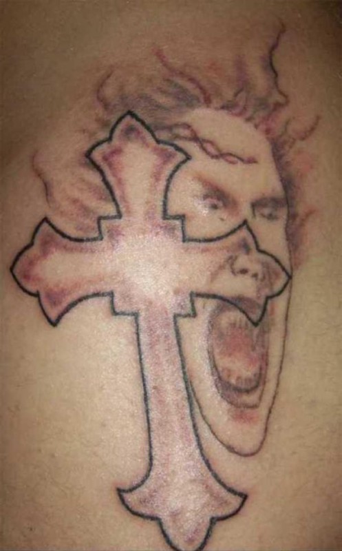Tatouage raté de croix et de visage