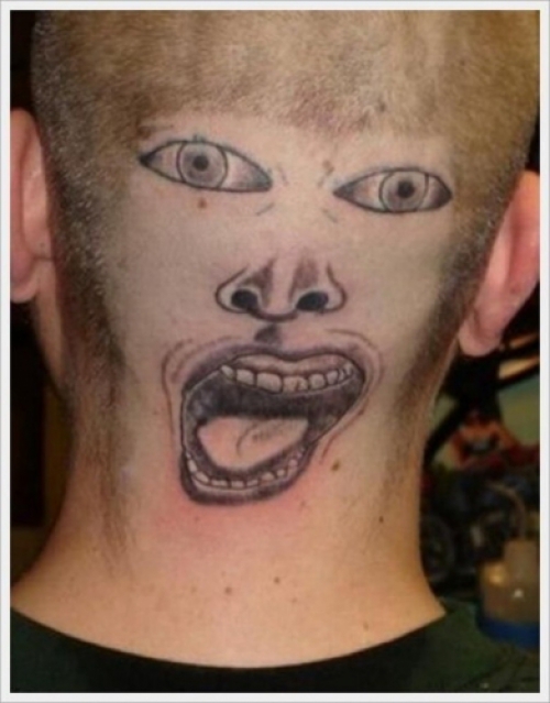 Tatouage raté de visage sur l'arrière de la tête